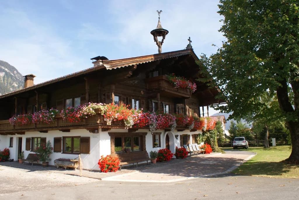 Traditioneller Tiroler Bauernhof Oberlacken mit Blumenkästen und Holzbalkonen in Sankt Johann in Tirol.
